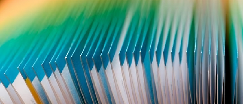 Close-up of a stack of blue,white and green files