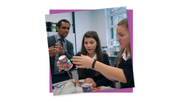 Os alunos trabalham em um projeto do MakeCode enquanto o professor assiste.