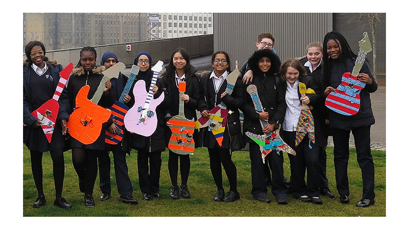 Studenter med pappgitarer laget med MakeCode.
