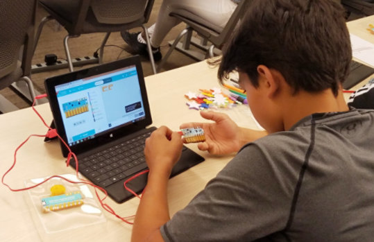 A young student works with the Chibi Chip hardware in a classroom.