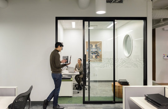 Zwei junge Menschen unterhalten sich in ihrem Büro