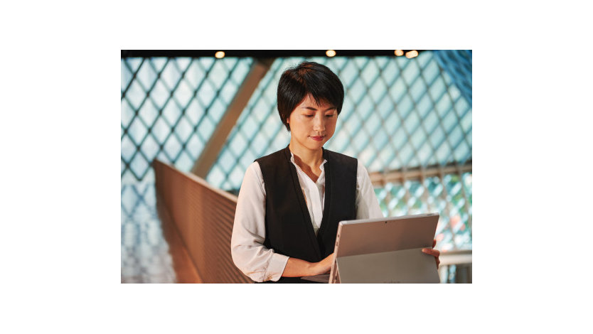 Image shows a woman working on a  Laptop,