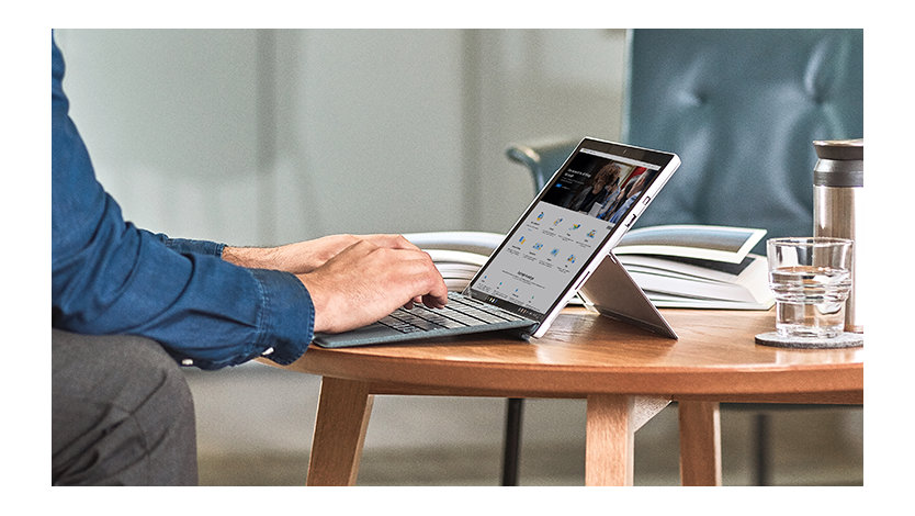 Une personne se connectant sur sa tablette Surface posée sur une table basse