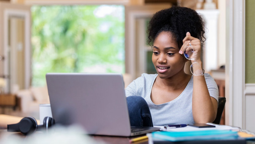 Photo credit: iStock/SDI Productions/Getty Images. Female college student uses laptop at home