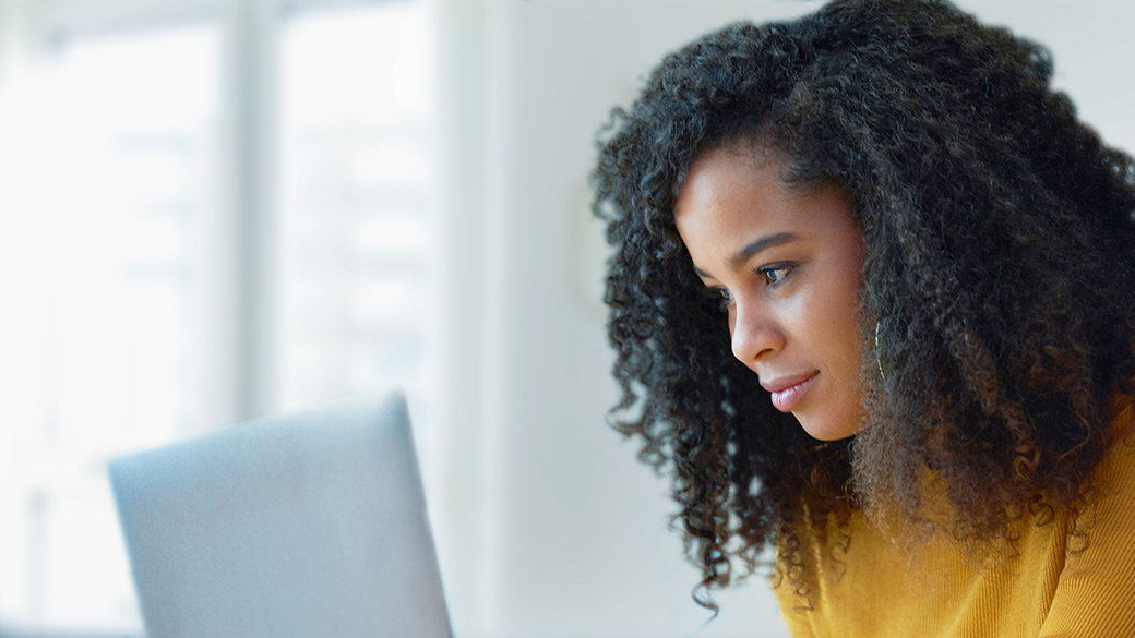 Woman using laptop to edit her résumé.