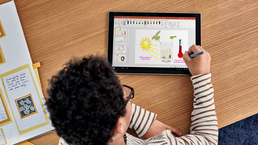 A young student working on a PowerPoint presentation with a digital pen