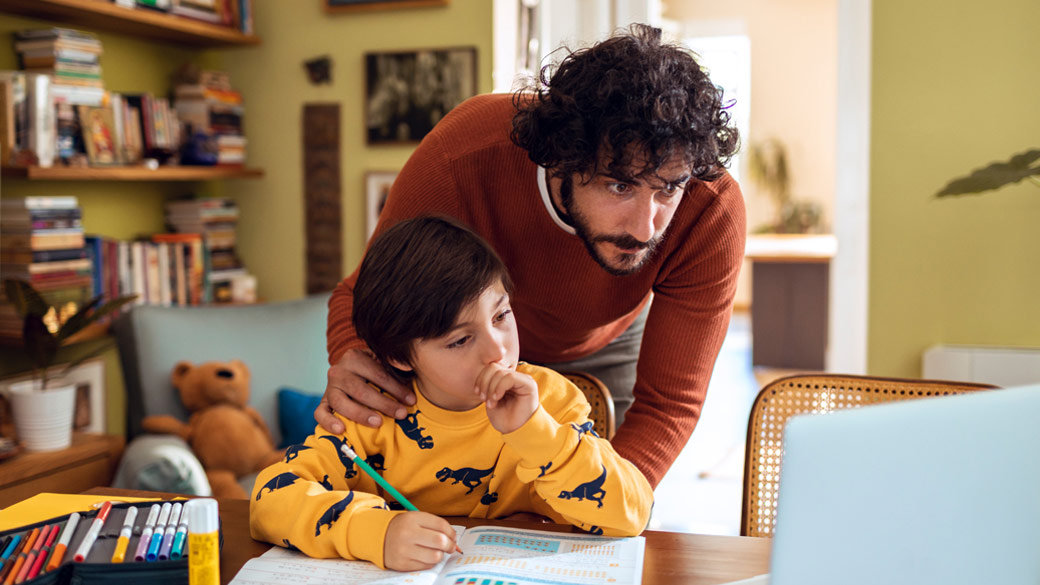 Photo credit: Marko Geber/DigitalVision/Getty Images. Father helping son with schoolwork at home.