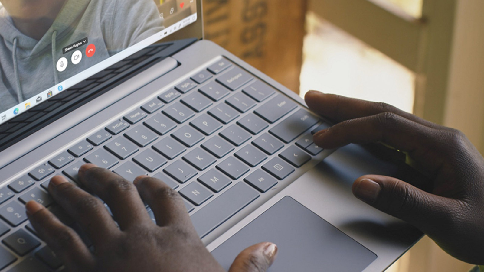 Una persona digita su un Surface Laptop Go durante una videochiamata.