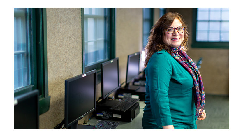 A person smiling in a computer lab.