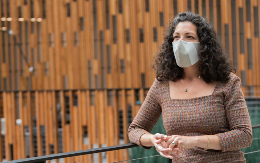 Two businesspeople talking at a distance with masks on. 