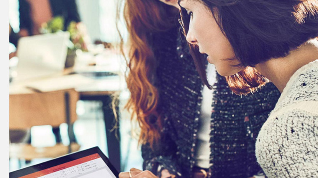 Two women looking at a tablet device.