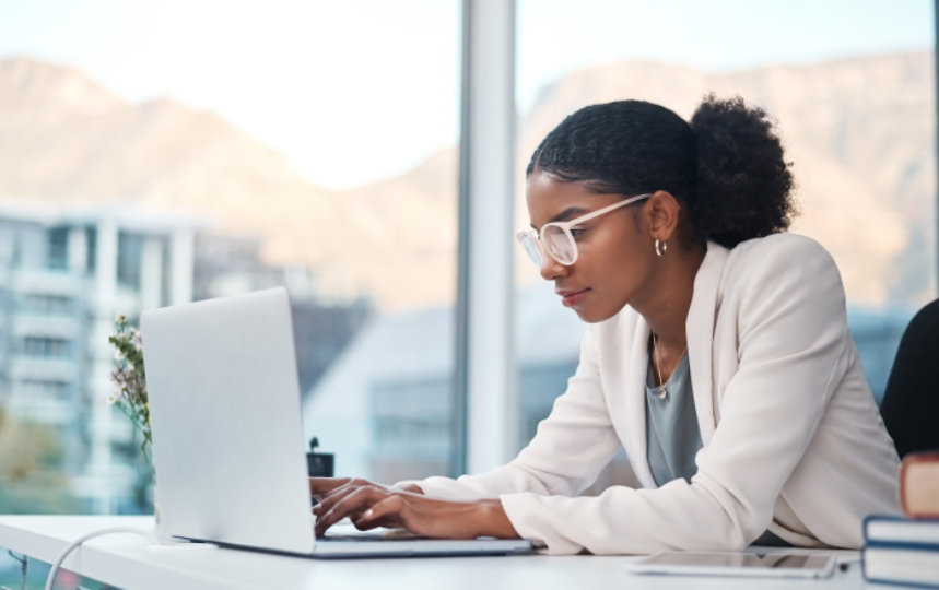 Shot of a young businesswoman using a laptop at her desk in a modern office