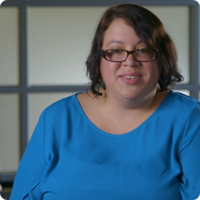 A job coach is speaking, she is wearing a blue top and glasses.