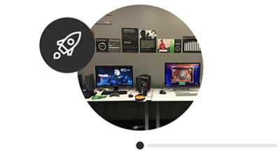 Two workstations at the Inclusive Tech Lab with game console, computers, and assistive technology.