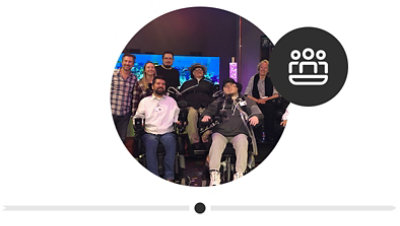 Seven people posing for a picture at the original Inclusive Design Lab, four of them are men who are tetraplegics in wheelchairs.