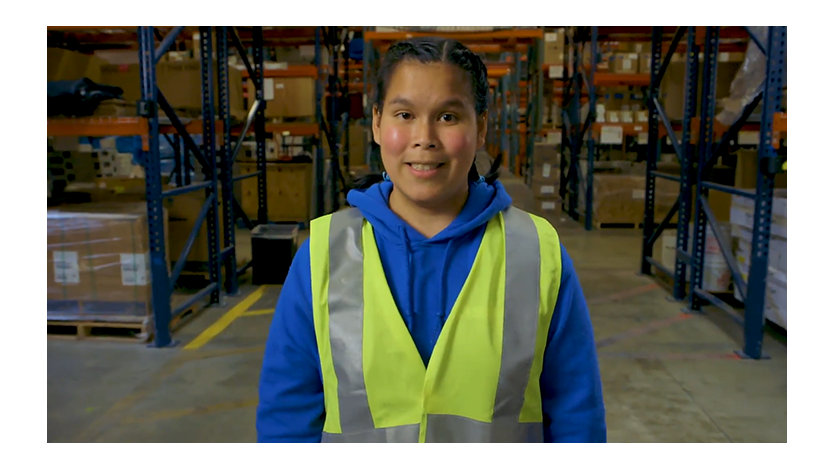 Tanya Harris wearing a safety vest in a warehouse