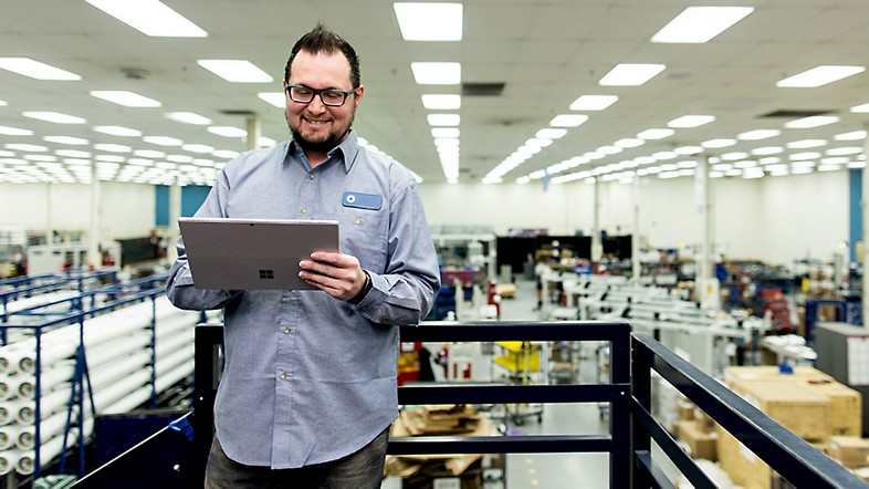 Man in warehouse working on Microsoft Surface