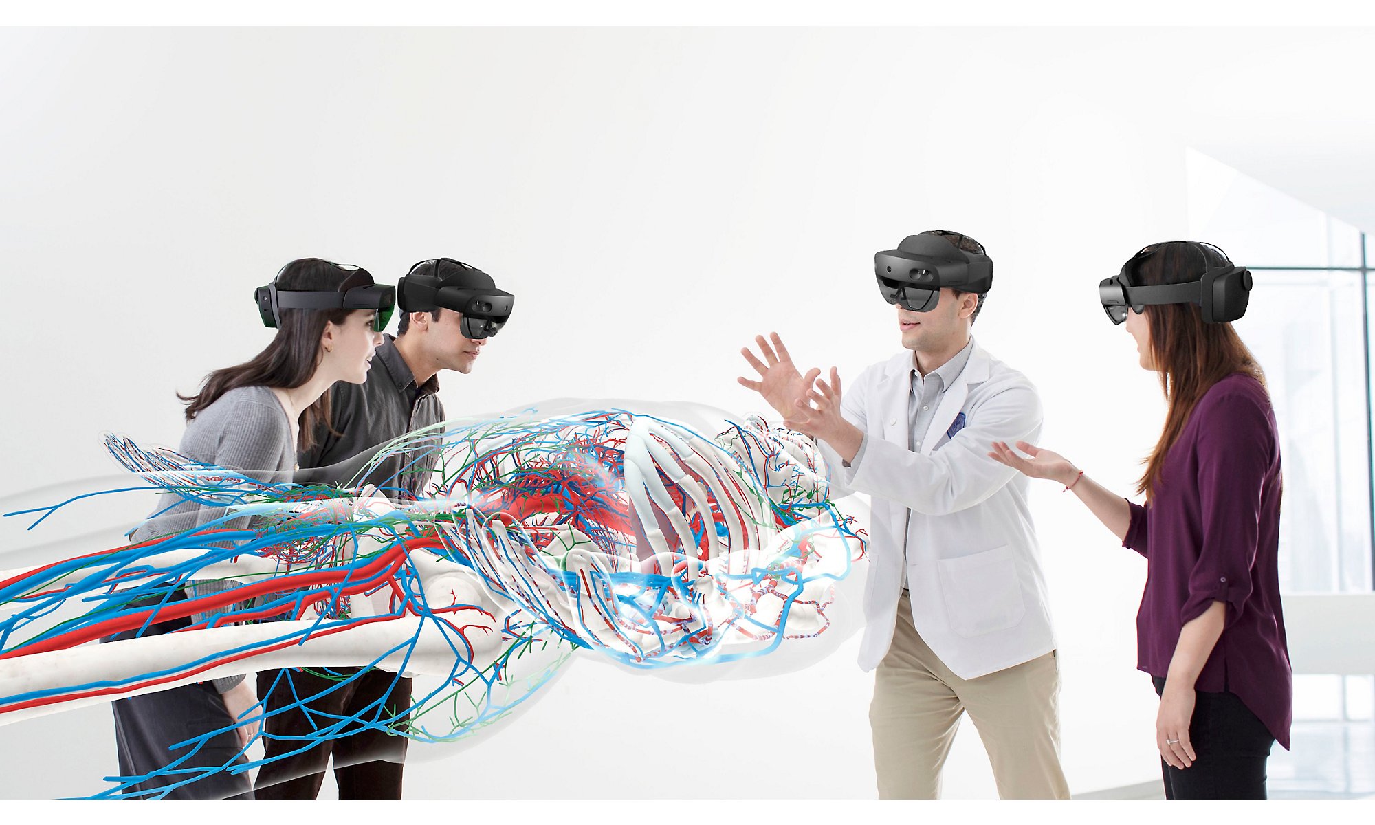 Четыре человека в устройствах устройства HoloLens 2 рассматривают большое человеческое тело и вены в нем.