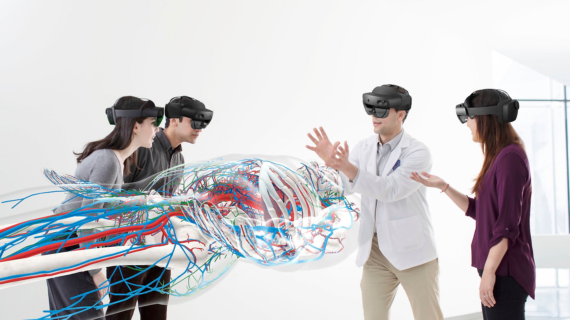 Vier Personen, die HoloLens 2-Geräte tragen, um einen großen menschlichen Körper und die Adern darin zu betrachten.
