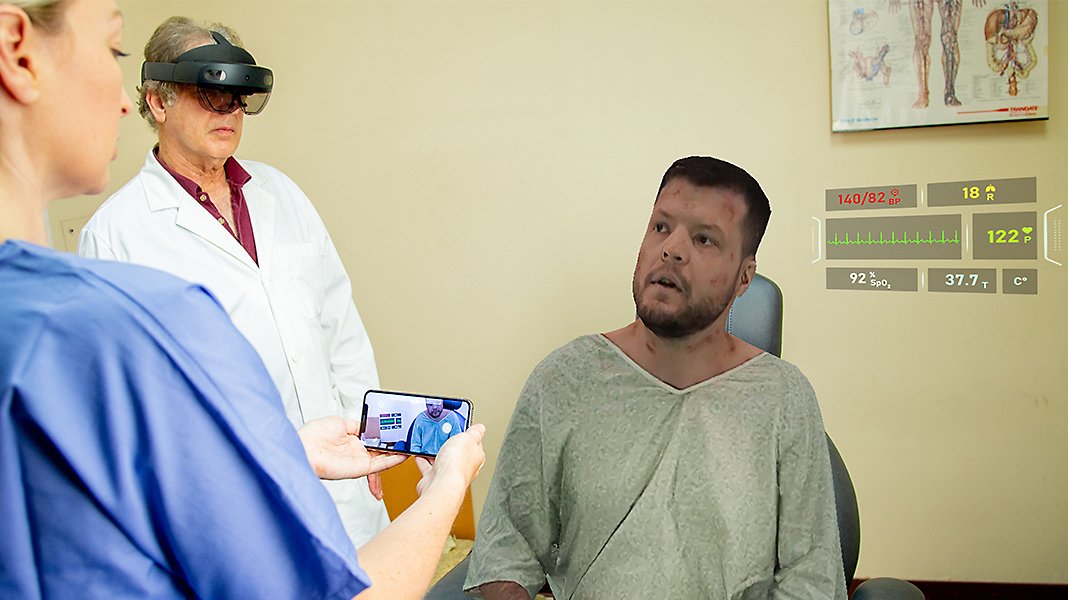 Zwei Mediziner verwenden die HoloLens 2, um sich mit einem Patienten zu unterhalten.