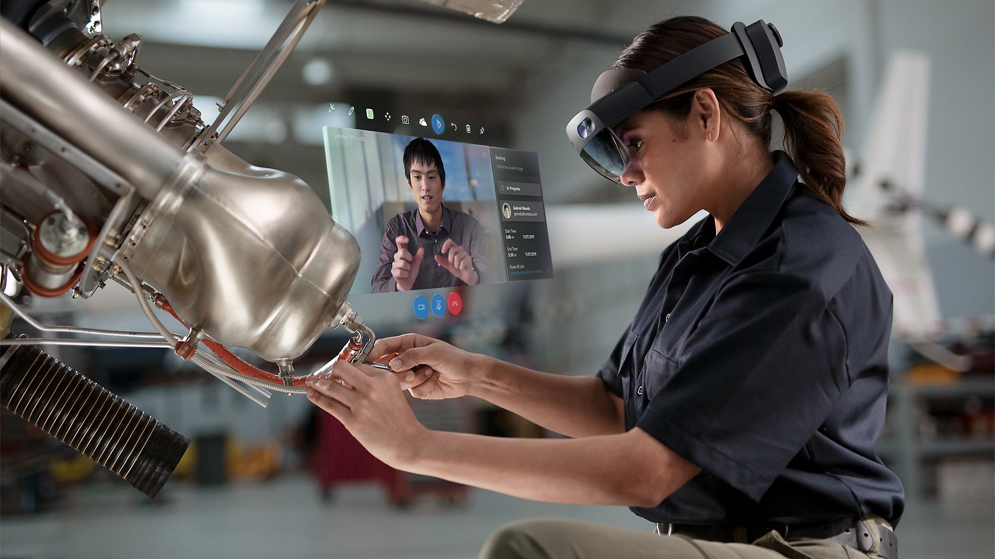 Ein Fachmann, der an einer Maschine arbeitet und die HoloLens 2 verwendet, um gleichzeitig an einem Teams-Anruf teilzunehmen.