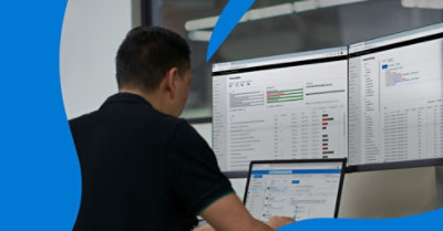 People working in the Microsoft Security Response Center, looking at information on large desktop monitors.