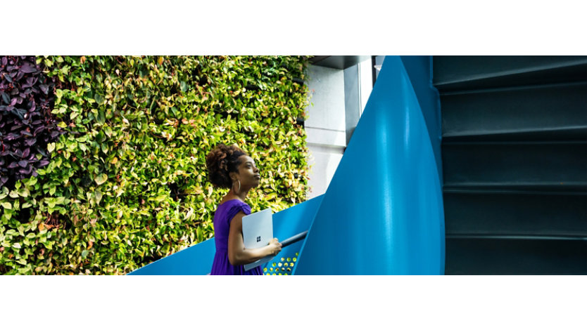 A female tech industry employee walks up a spiral staircase outside of U.S. office.