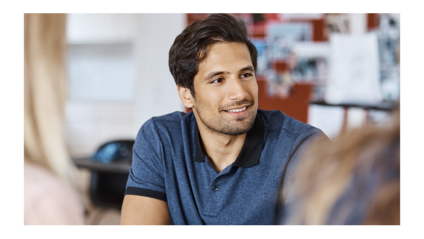 Smiling businessman discussing with colleagues.