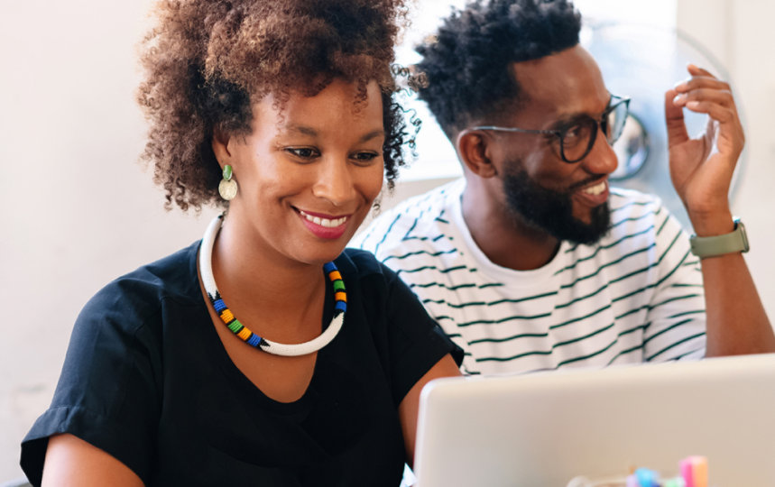 A man and a woman working together on a laptop.