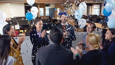 Microsoft employees celebrating an accomplishment in a gathering space in a Microsoft office.