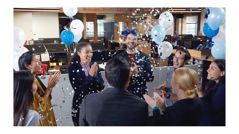 Microsoft employees celebrating an accomplishment in a gathering space in a Microsoft office.