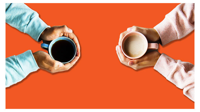 An overhead shot of two people holding coffee cups on an orange background