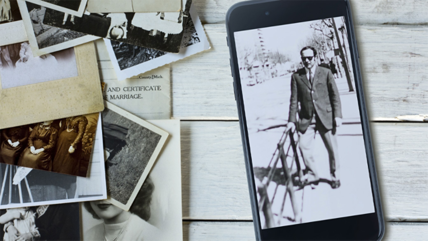 Old family photos and smartphone showing a photo