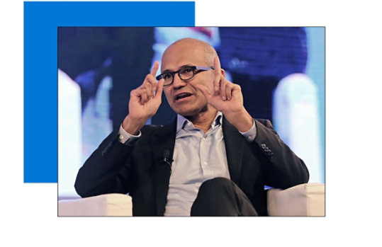 A photograph of Satya Nadella gesturing with both hands