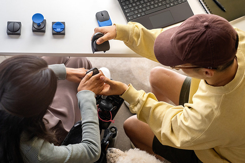 An occupational therapist and a client use Microsoft adaptive accessories with a Surface Pro 9.