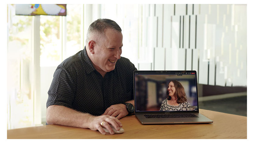 A photograph of two people connecting via an online meeting