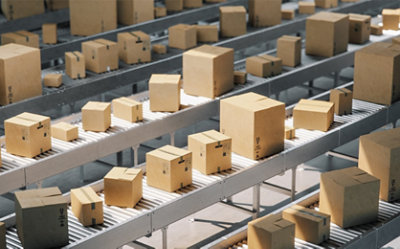 Cardboard boxes on conveyor belts in a distribution warehouse.