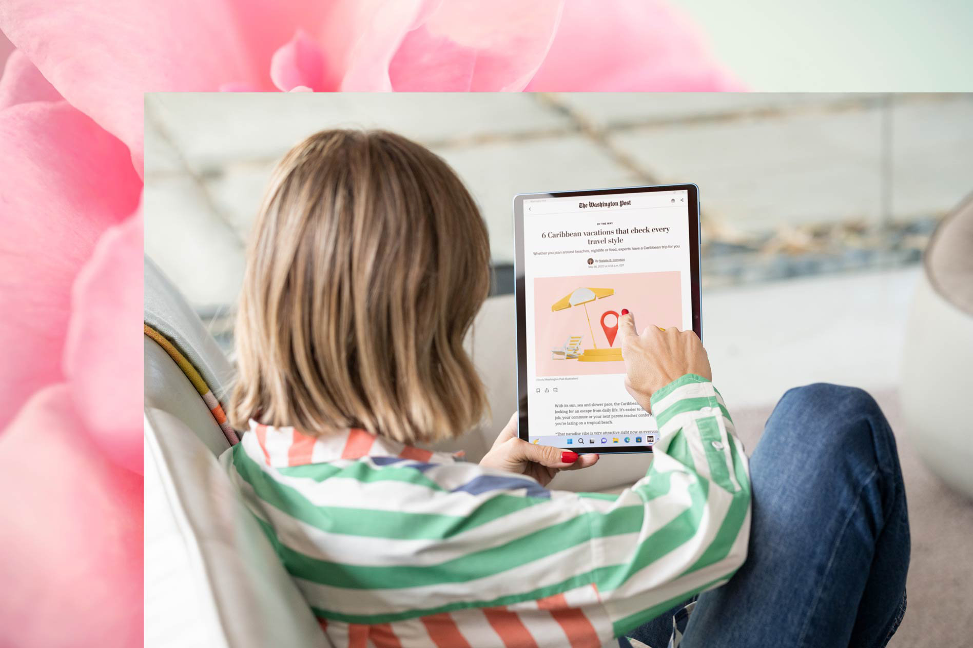 A woman uses Surface Pro 9 to catch up on news while sitting on her couch.