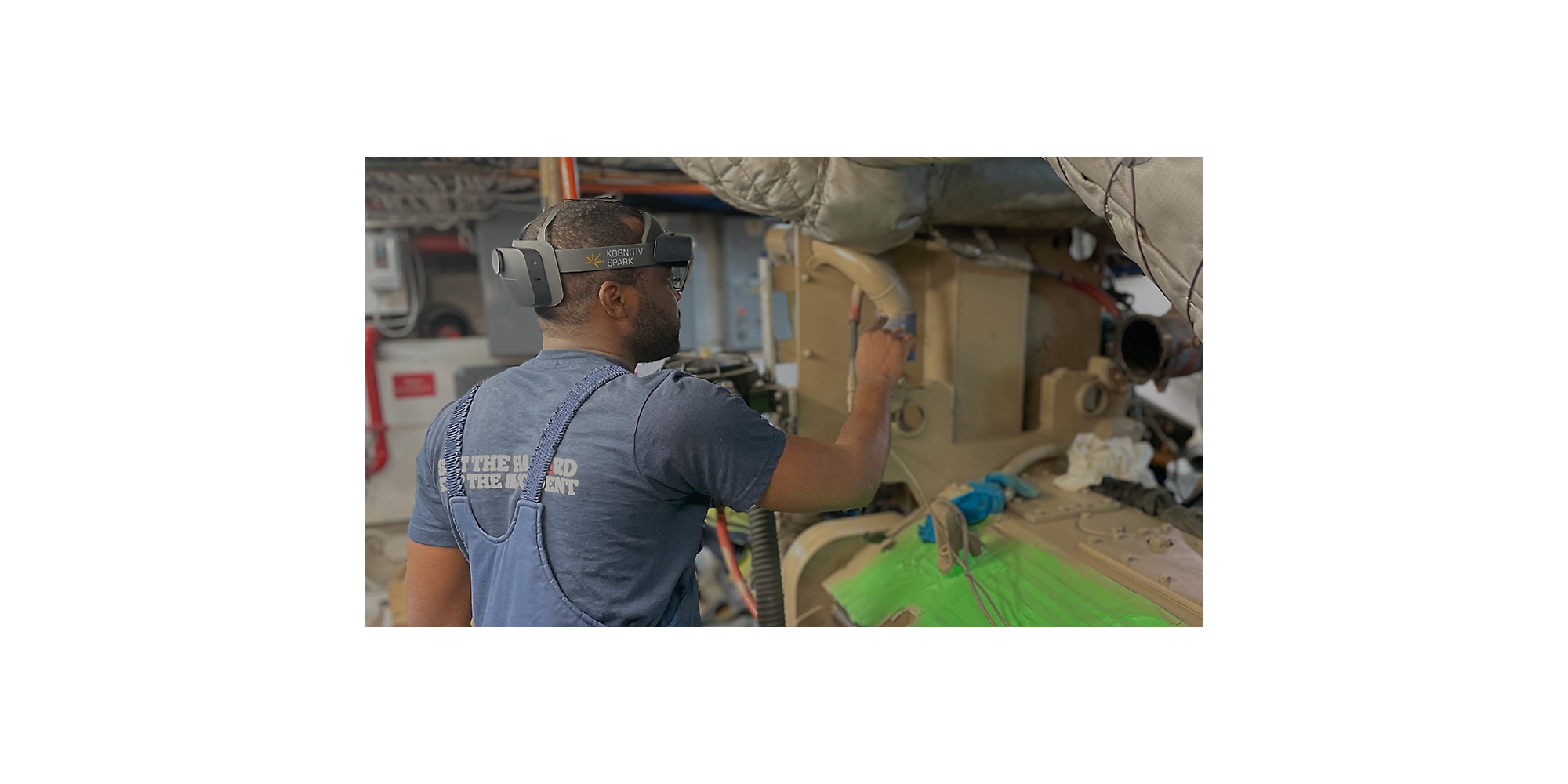 HoloLens 2 takarak büyük bir makine parçası üzerinde çalışan bir kişi.