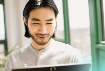 Una persona sonríe mientras mira un portátil 