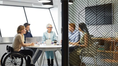 Cinco miembros de un equipo celebran una reunión en una sala de conferencias.