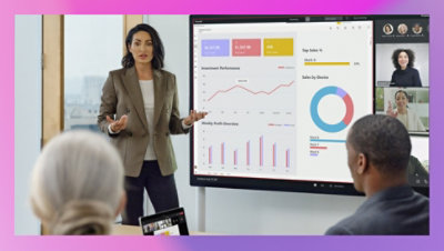 Osoba drži prezentaciju učesnicima u sobi i u Teams video pozivu koji se prikazuje na velikom ekranu iza njih. 