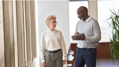 Two co-workers talking in a work commons area
