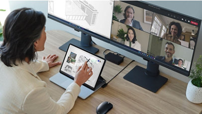A man working at his desk, with a Teams call showing on his monitor