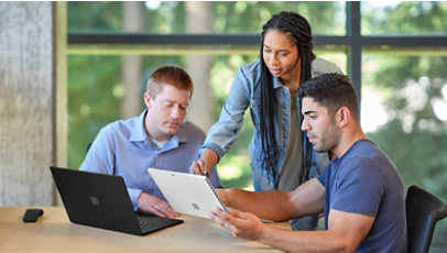 Three co-workers collaborating on a laptop