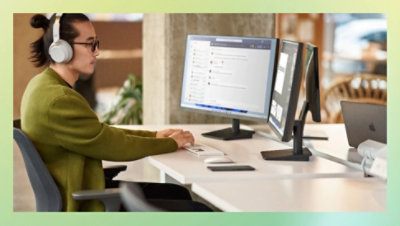 Osoba nosi slušalice preko ušiju i radi za radnim stolom.