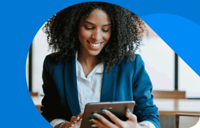 A person smiling and using a tablet.