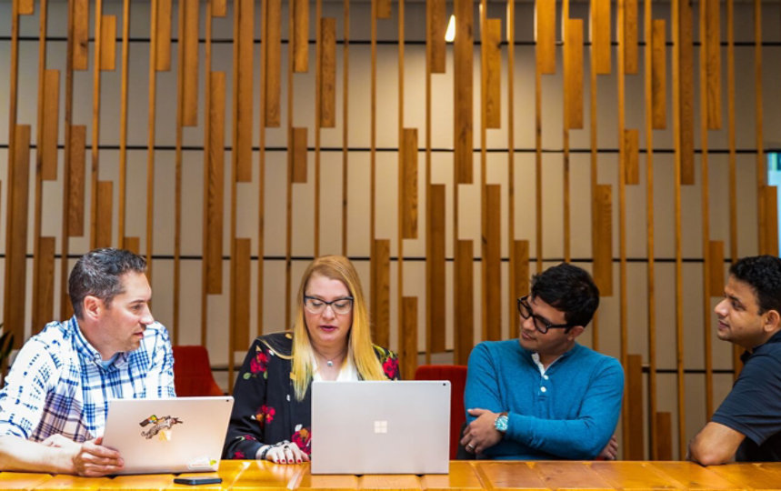 Microsoft employees gathered in a hybrid workspace.