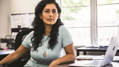 A Microsoft employee looks up from her desk in a Microsoft open space.