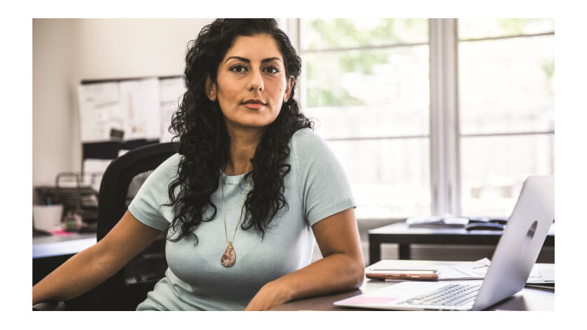 A Microsoft employee looks up from her desk in a Microsoft open space.